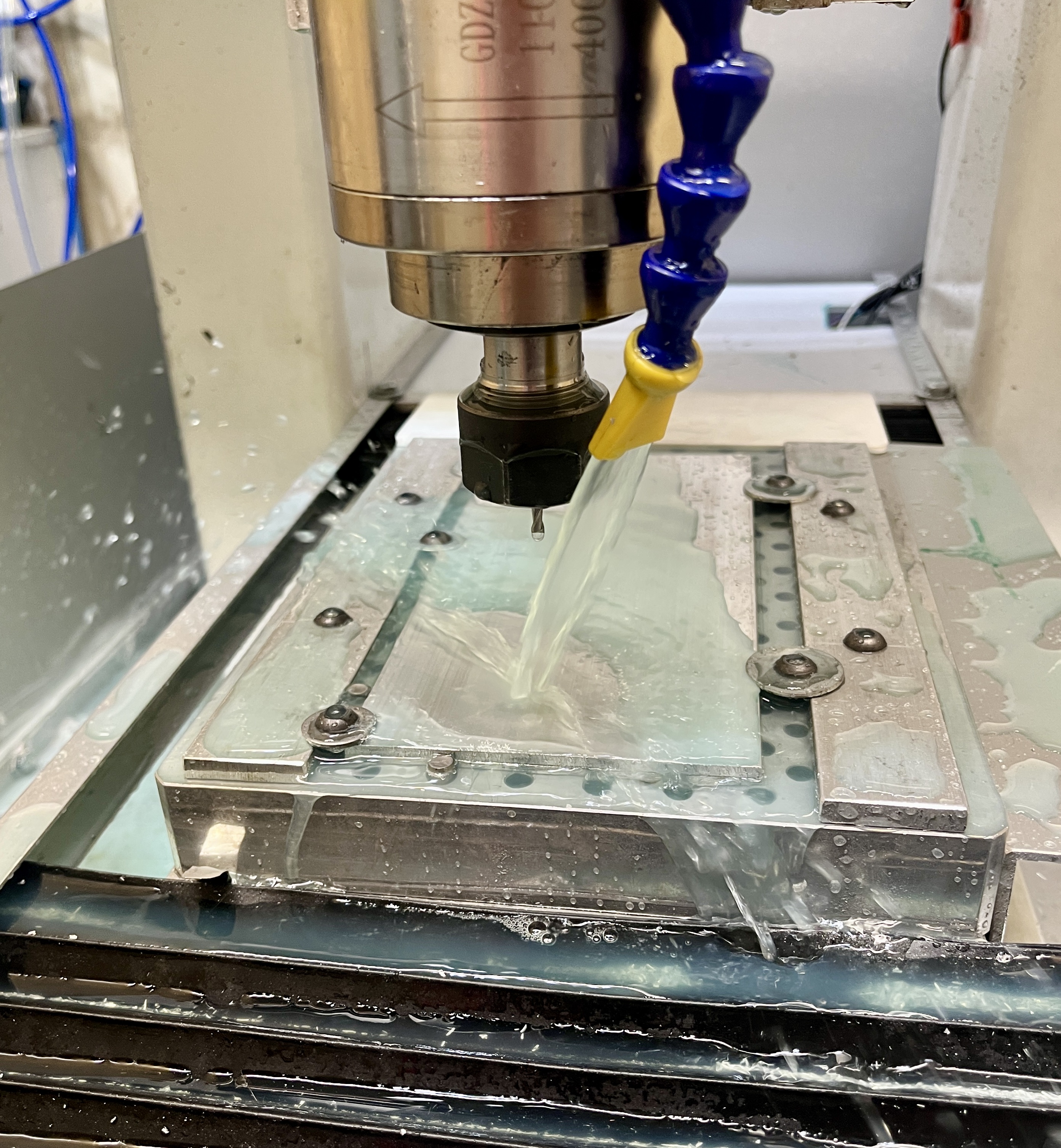 CNC mill table with cutter about to cut aluminum block in vise.